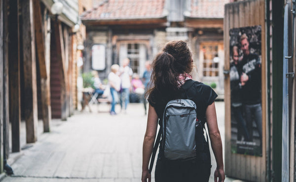 A person wearing the top pocket of the Hero's Journey as a backpack.